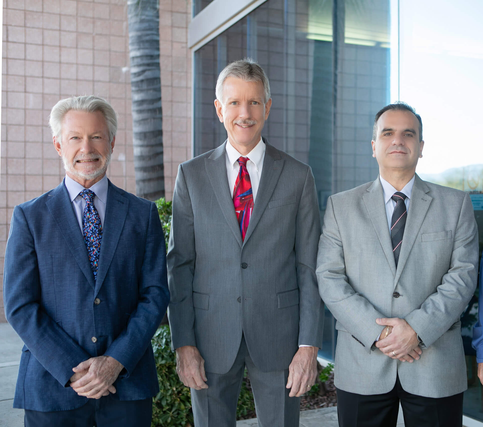 3 male healthcare professionals in suits standing outside of a digestive healthcare center in Tucson
