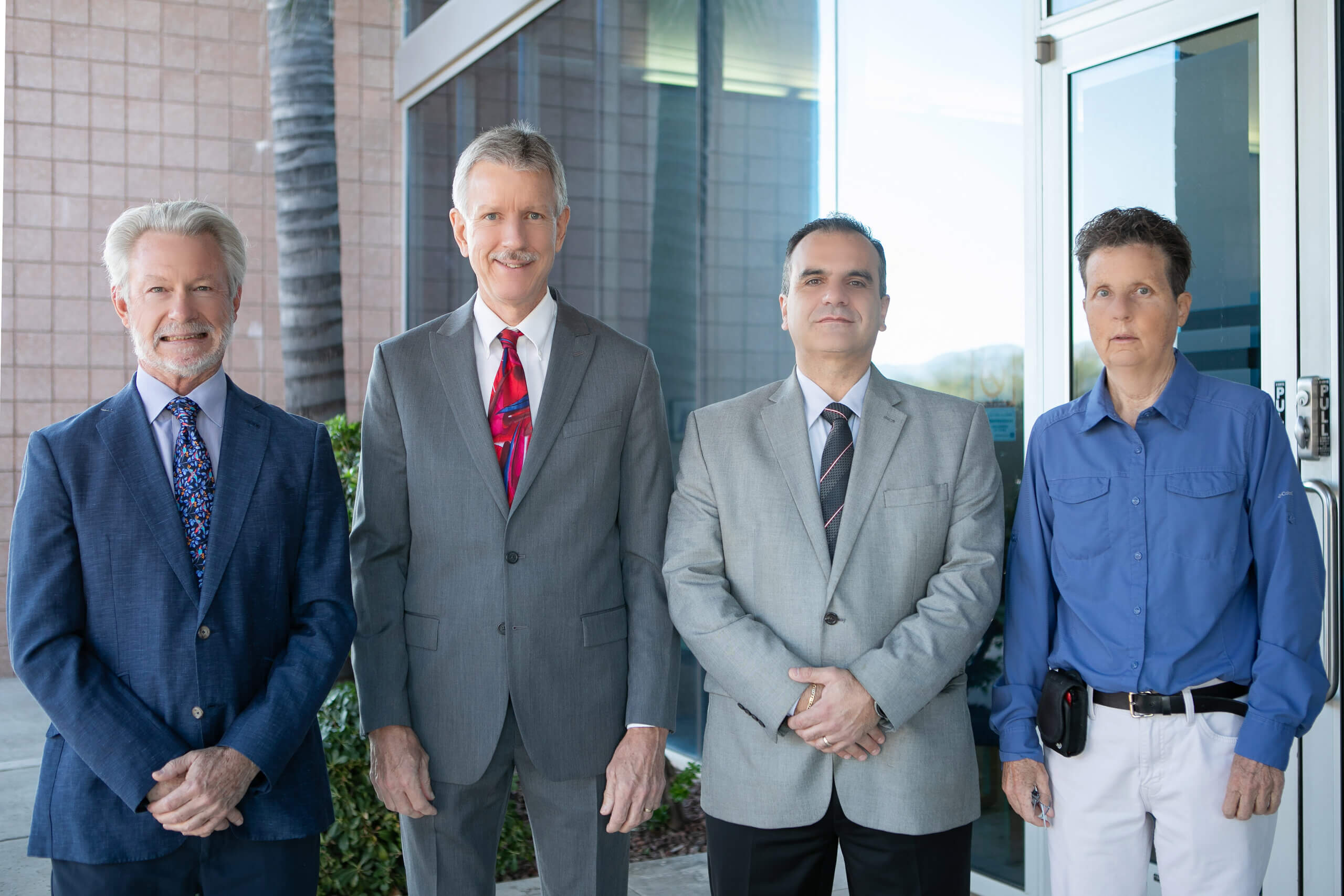 4 male healthcare professionals in suits standing outside of a digestive healthcare center in Tucson